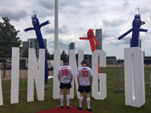 Boys in football kit in front of big letters.