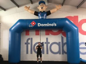 Giant inflatable domino's arch with man on top