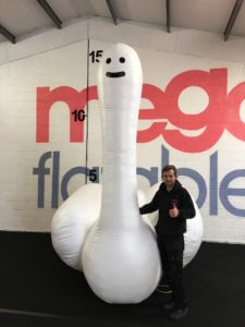 Man with giant swan inflatable, front angle