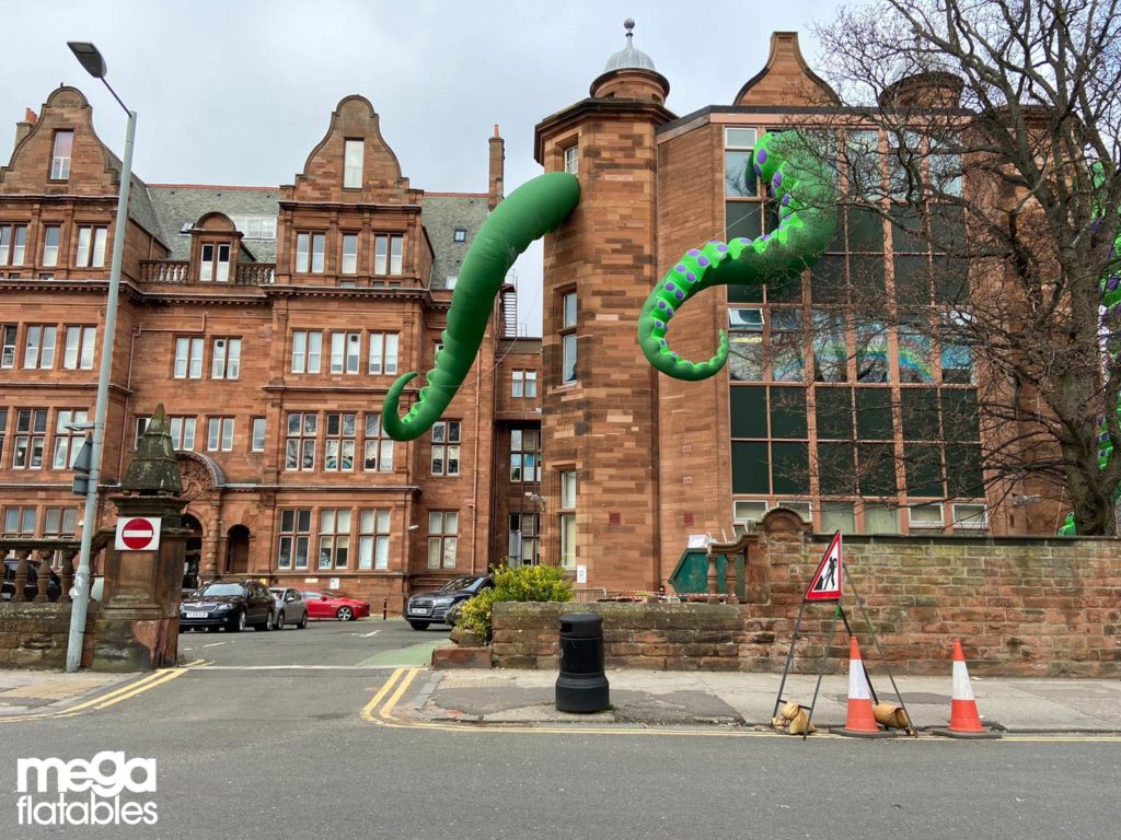 Inflatable monster arms coming from a bulding