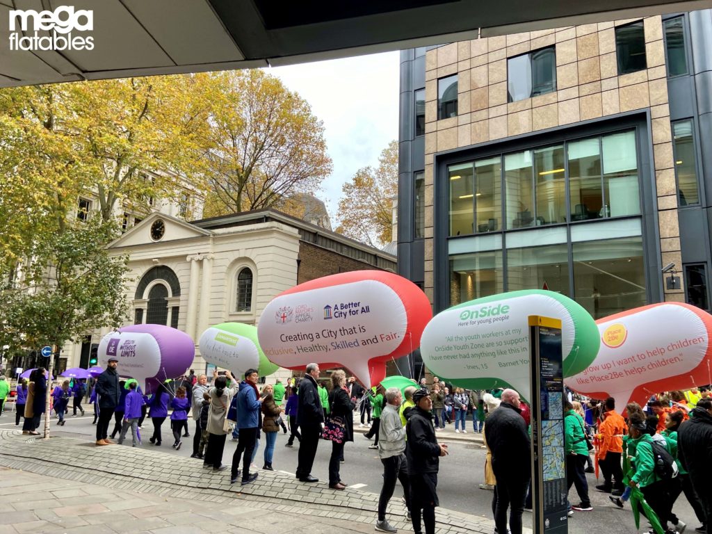 People walking with inflatables at lord mayor show 